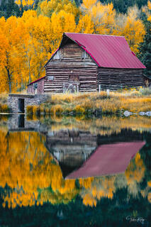 A Colorado rustic barn at the edge of a lake during autumn