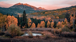 Autumn sunrise on an aspen forest and mountain