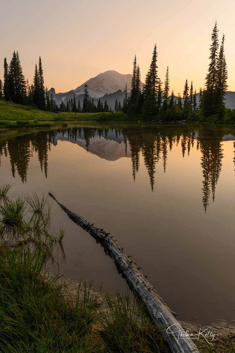 Alpine Heartthrob A rising sun makes its appearance on a tranquil morning and showing off Mt. Rainer's reflection in the calm water